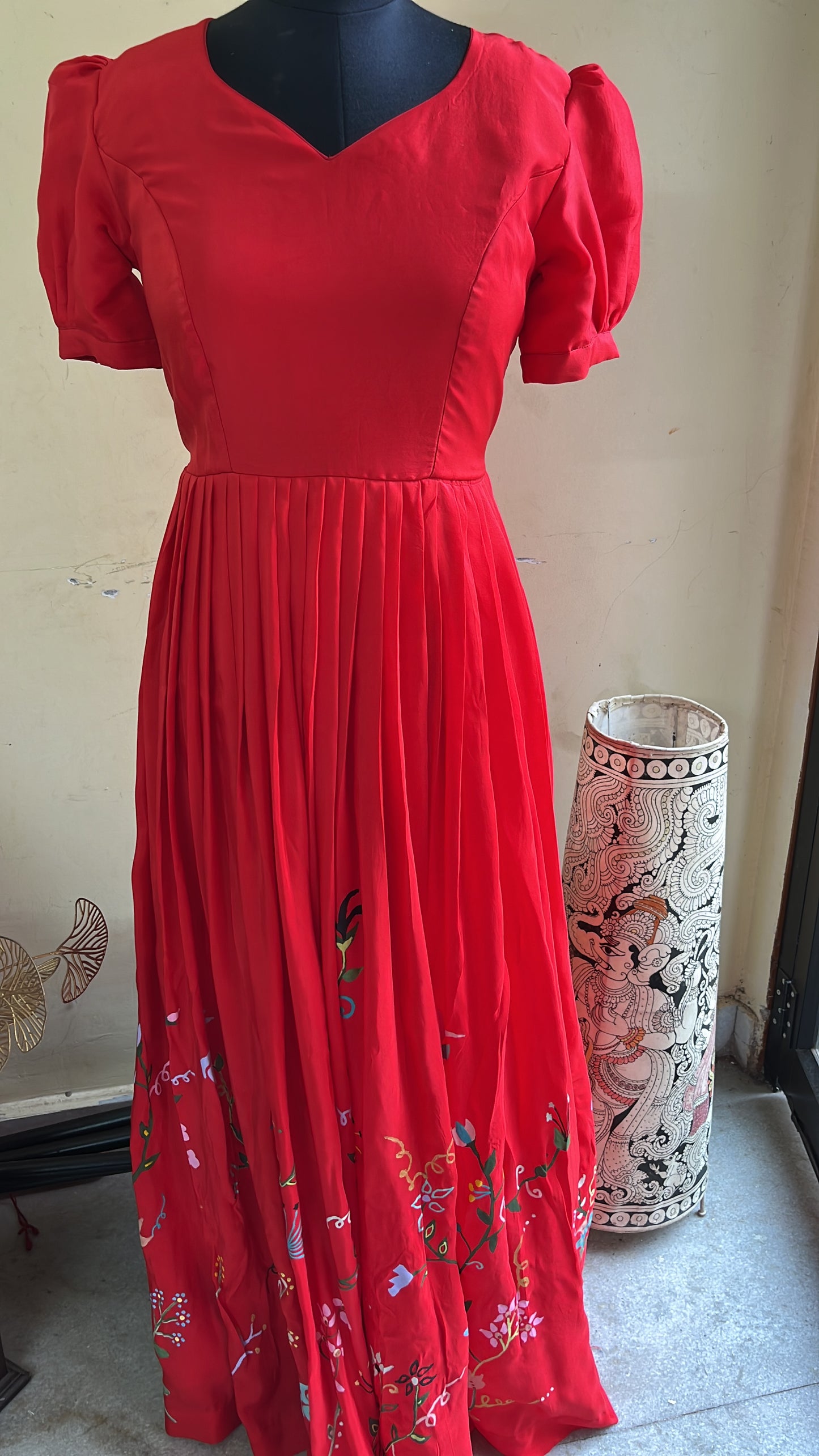 “Elegant Red Pleated Gown with Hand-Painted Floral Art”